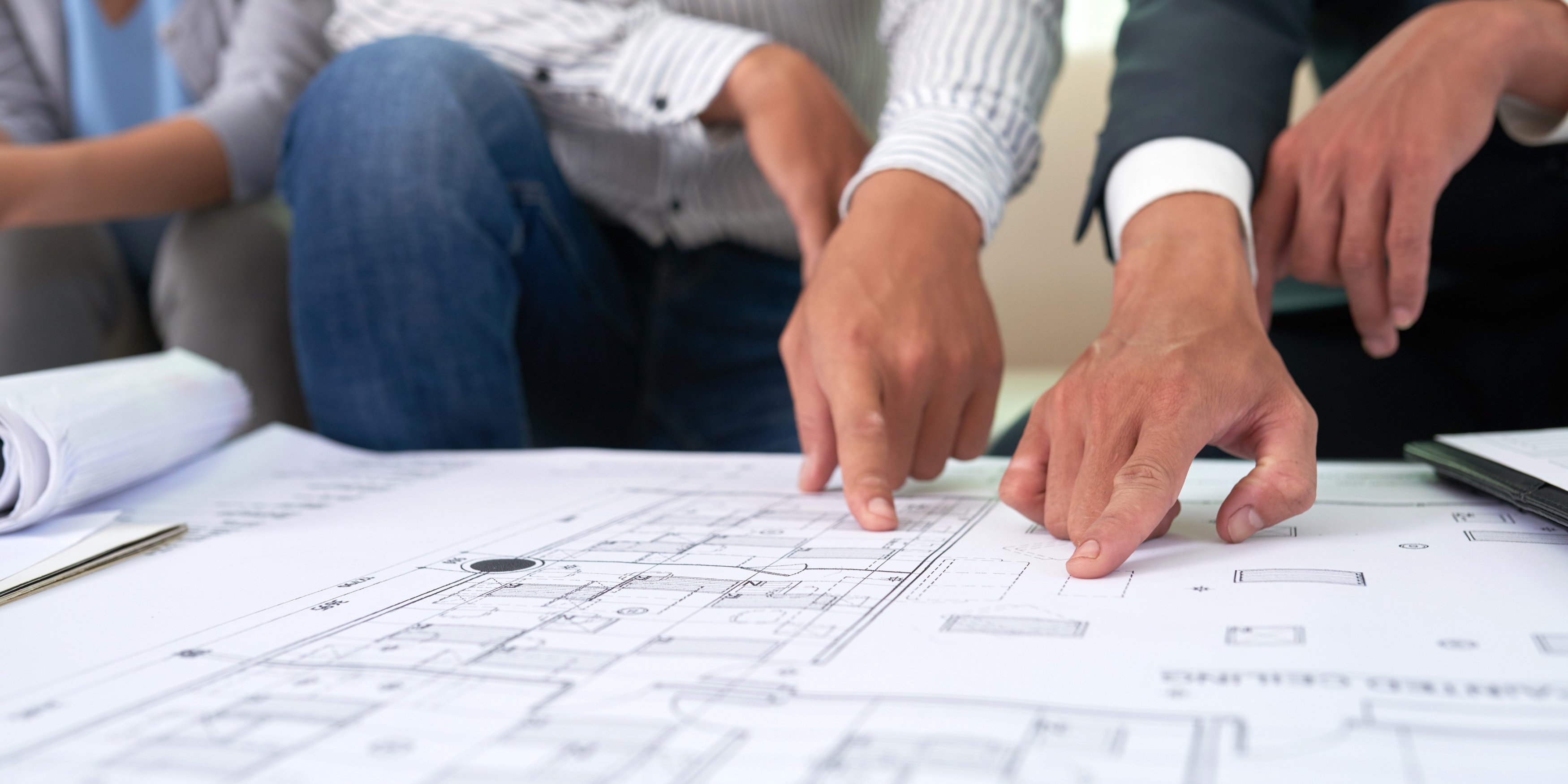 Building dispute experts reviewing construction plans during a technical conference